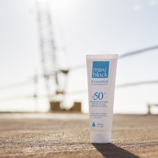 sunscreen tube sitting on concrete in front of a crane