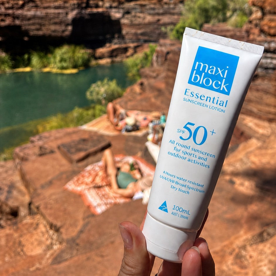 Close-up of a sunscreen tube with the cap clicked shut in front of a creek