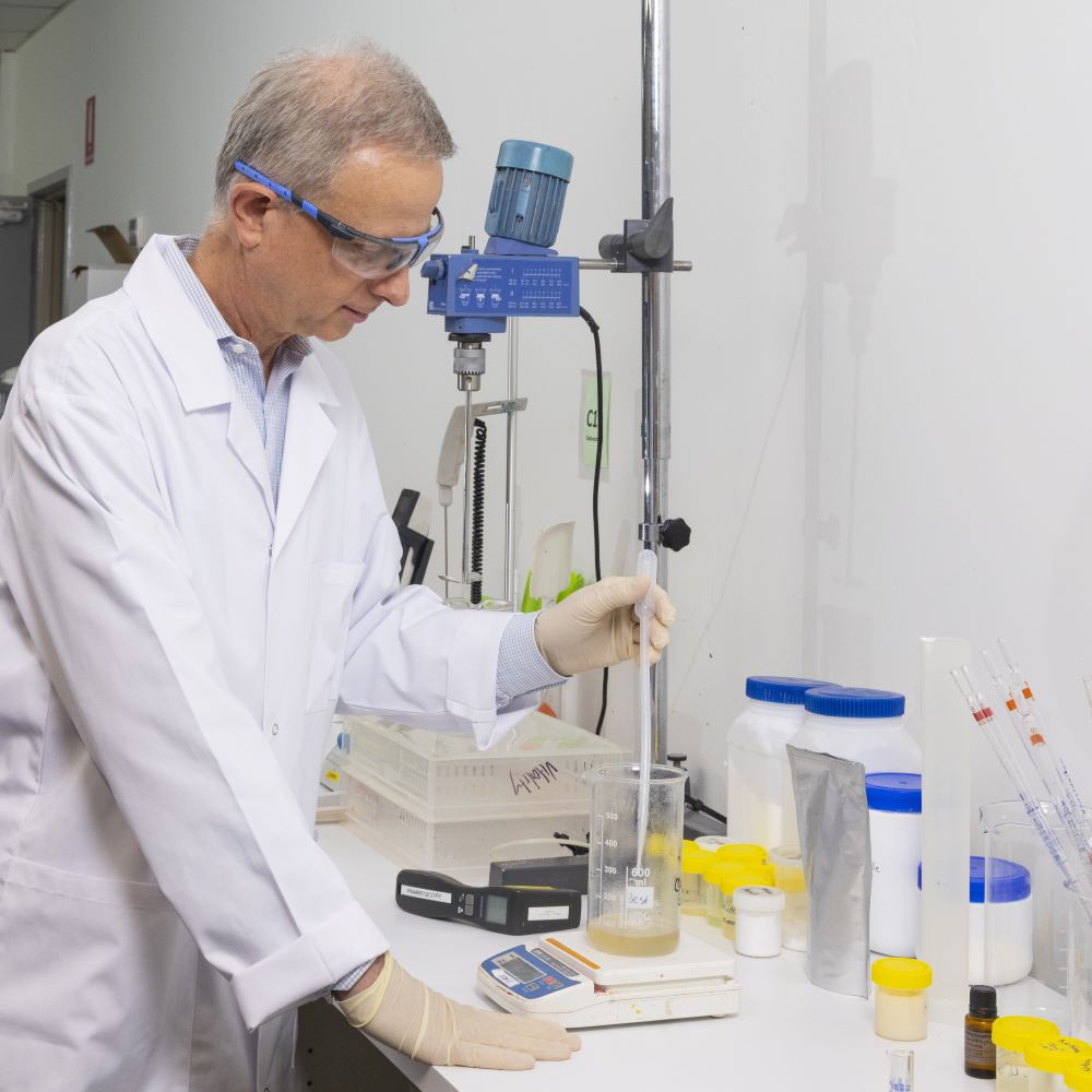 Thibaut Mortier wearing safety goggles and gloves, testing formulations in a laboratory