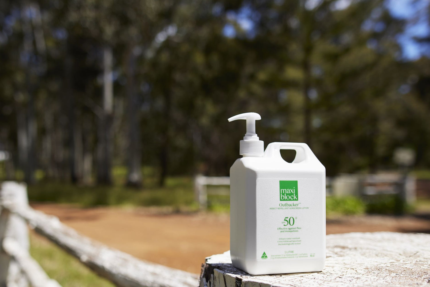 Maxiblock Outbacker sunscreen with insect repellent 1L pump bottle on a fence post, Australian bush setting