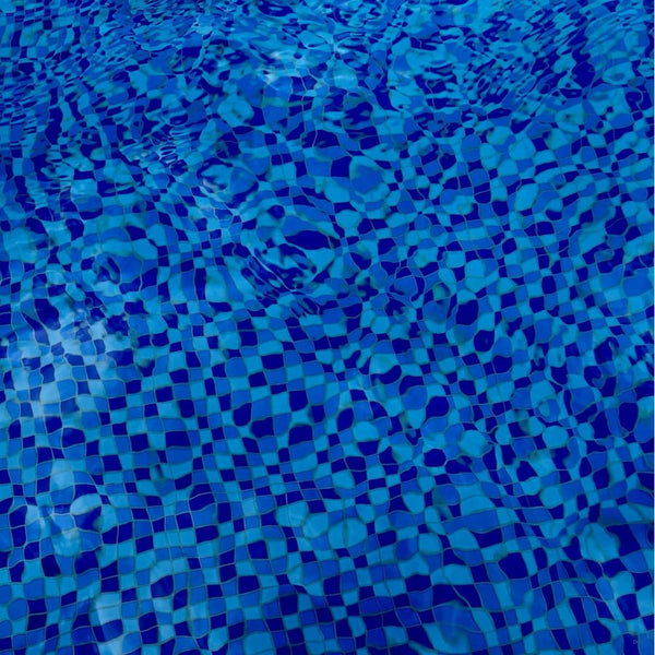 Close-up of blue mosaic pool tiles under water.
