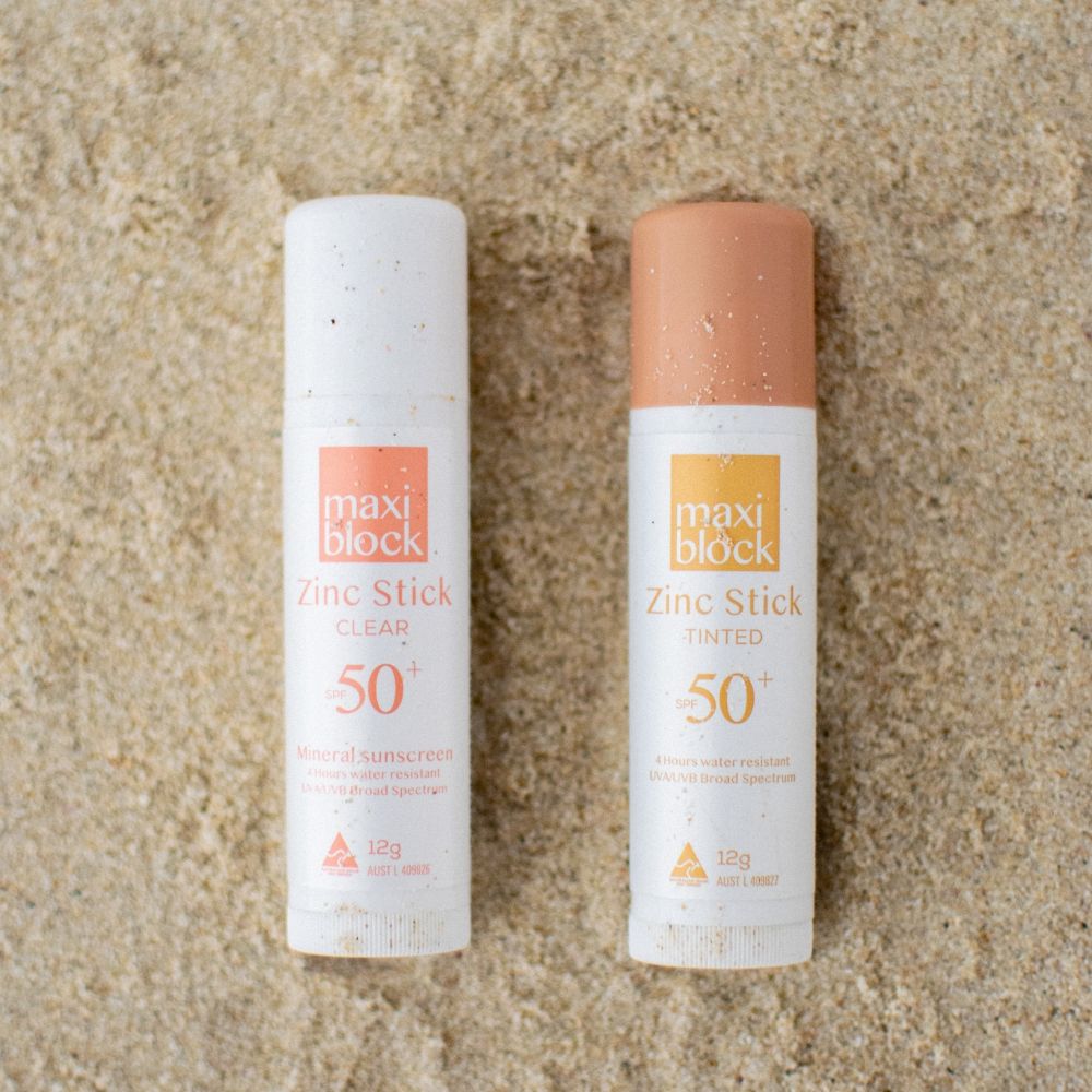 Maxiblock Clear Zinc Stick and Tinted Zinc Stick SPF 50+ side by side on sand