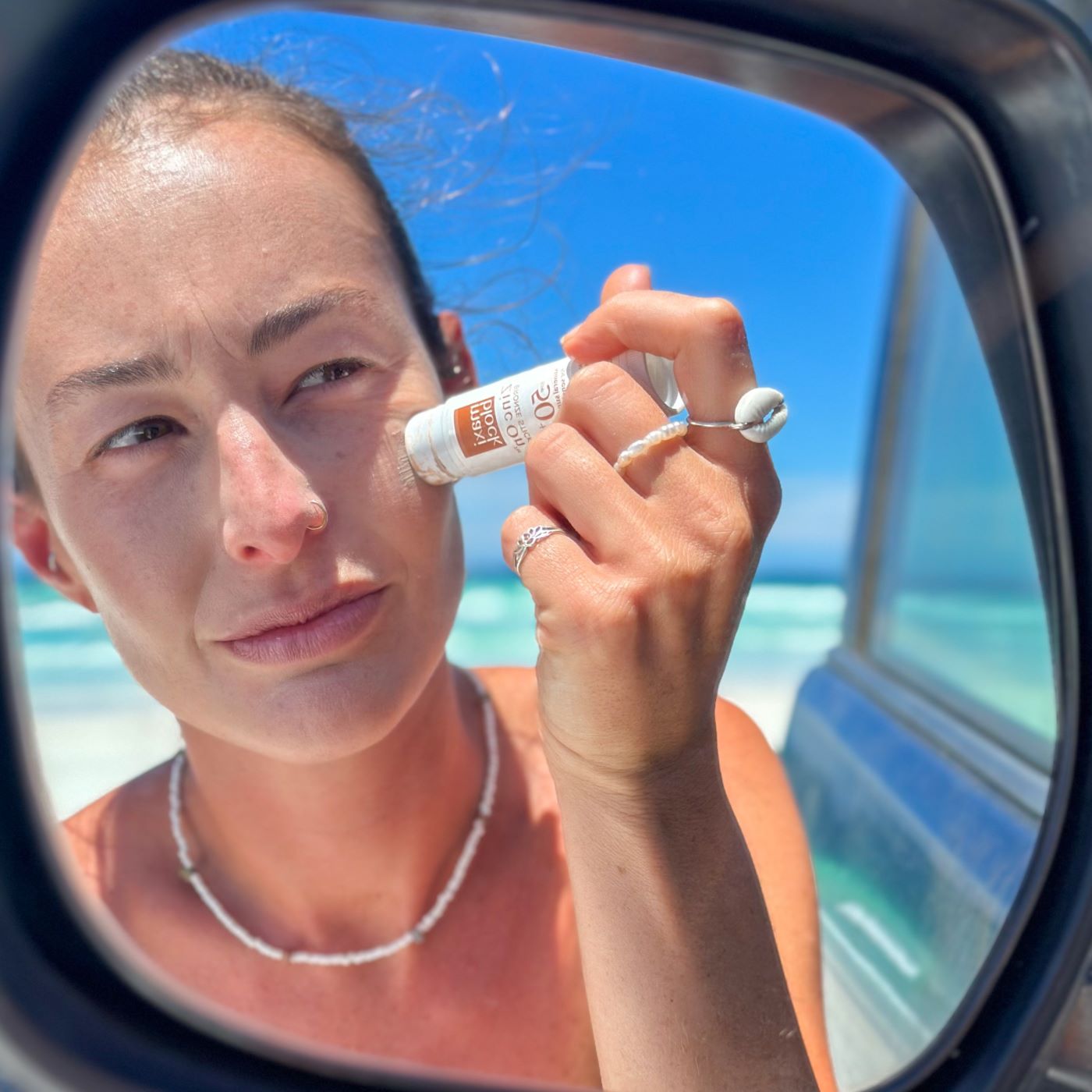 Woman applying zinc stick on her face