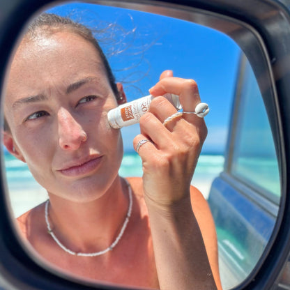 Woman applying zinc stick on her face